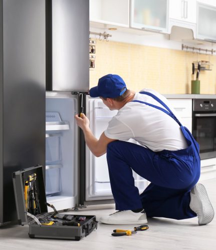 a technician repairing a refrigerator - Appliance Repair Roswell Pros